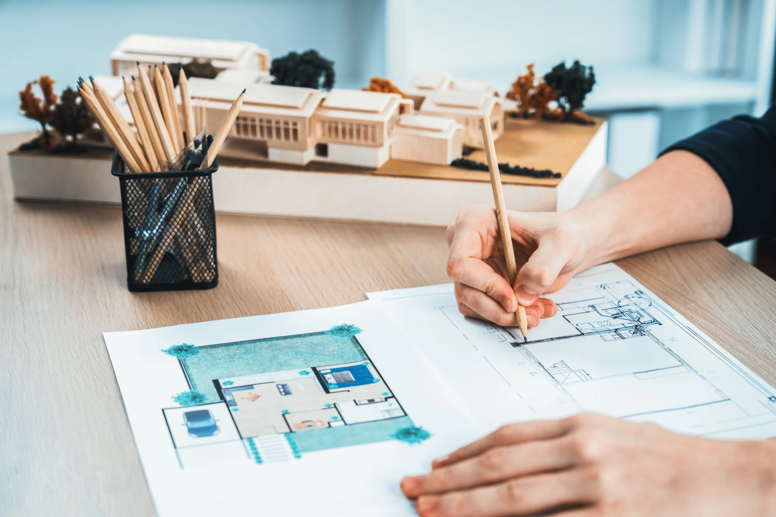 Elegant Custom Home Design In Defiance, MO | BECC Builders, LLC An architect designing floor plans of a new house.