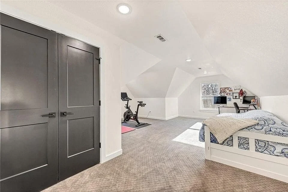 Functional Home Renovations In Troy, MO | BECC Builders, LLC A white attic with large doors, carpet flooring, a white bed, and an office space.