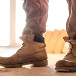 A close-up view of work boots being worn by someone on the construction site.